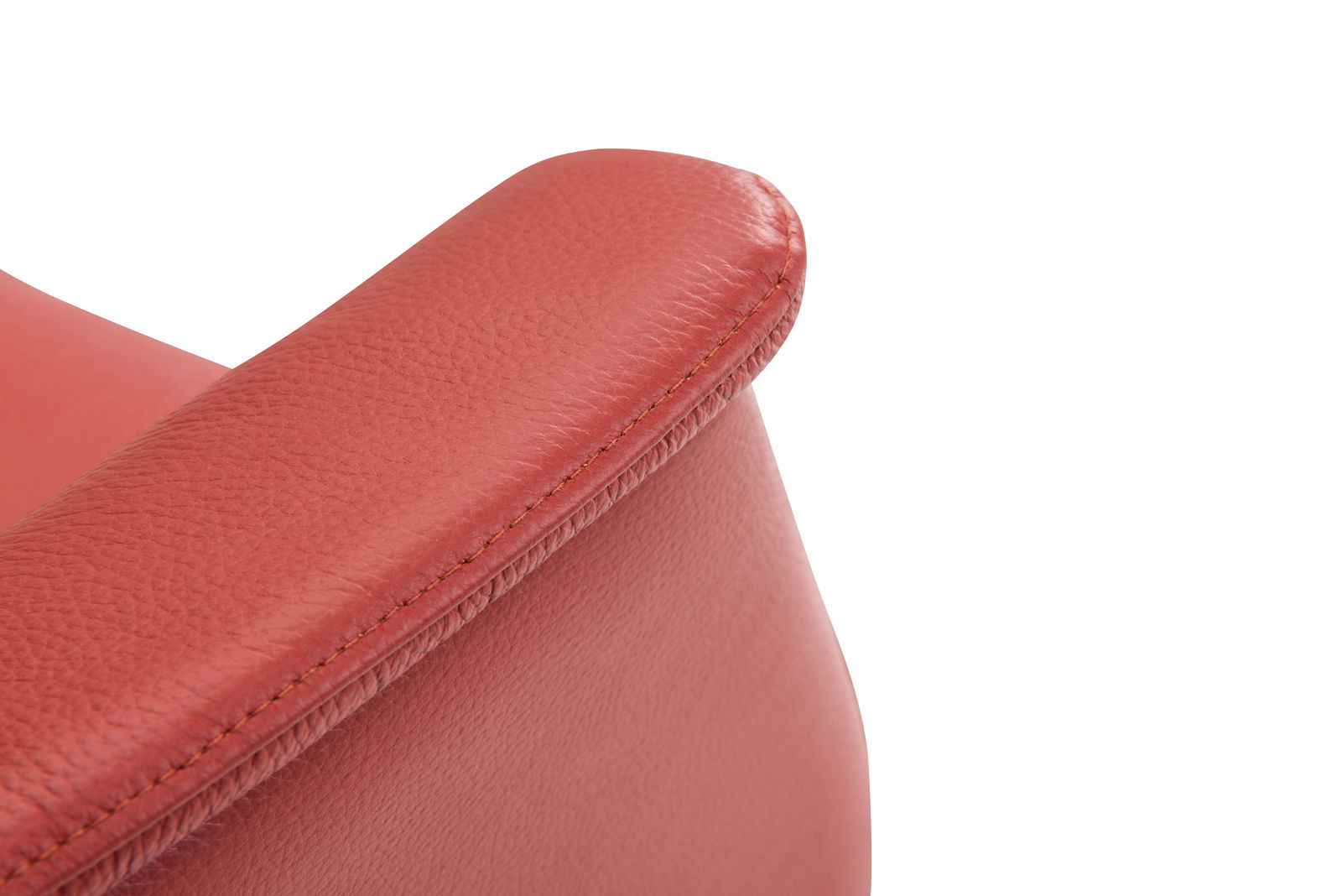 Nahaufnahme eines roten Ledersessels, Fokus auf die Armlehne, von oben betrachtet.