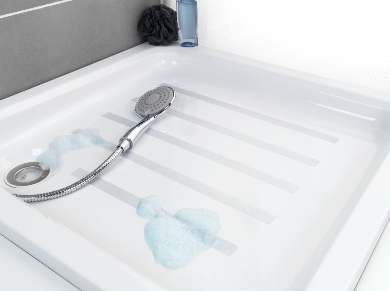 Blick von oben auf eine Duschwanne mit Anti-Rutschband und Duschkopf, umgeben von Seifenschaum.