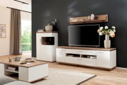 Moderne woonkamerset in wit en eikenlook, bestaande uit een tv-kast, vitrinekast, salontafel en wandplank, geplaatst voor een donkere muur, in perspectief vanuit een licht zijdelings vooraanzicht