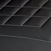 Nahaufnahme der schwarzen, gesteppten Lederoberfläche eines Gamingstuhls mit weißen Nähten.