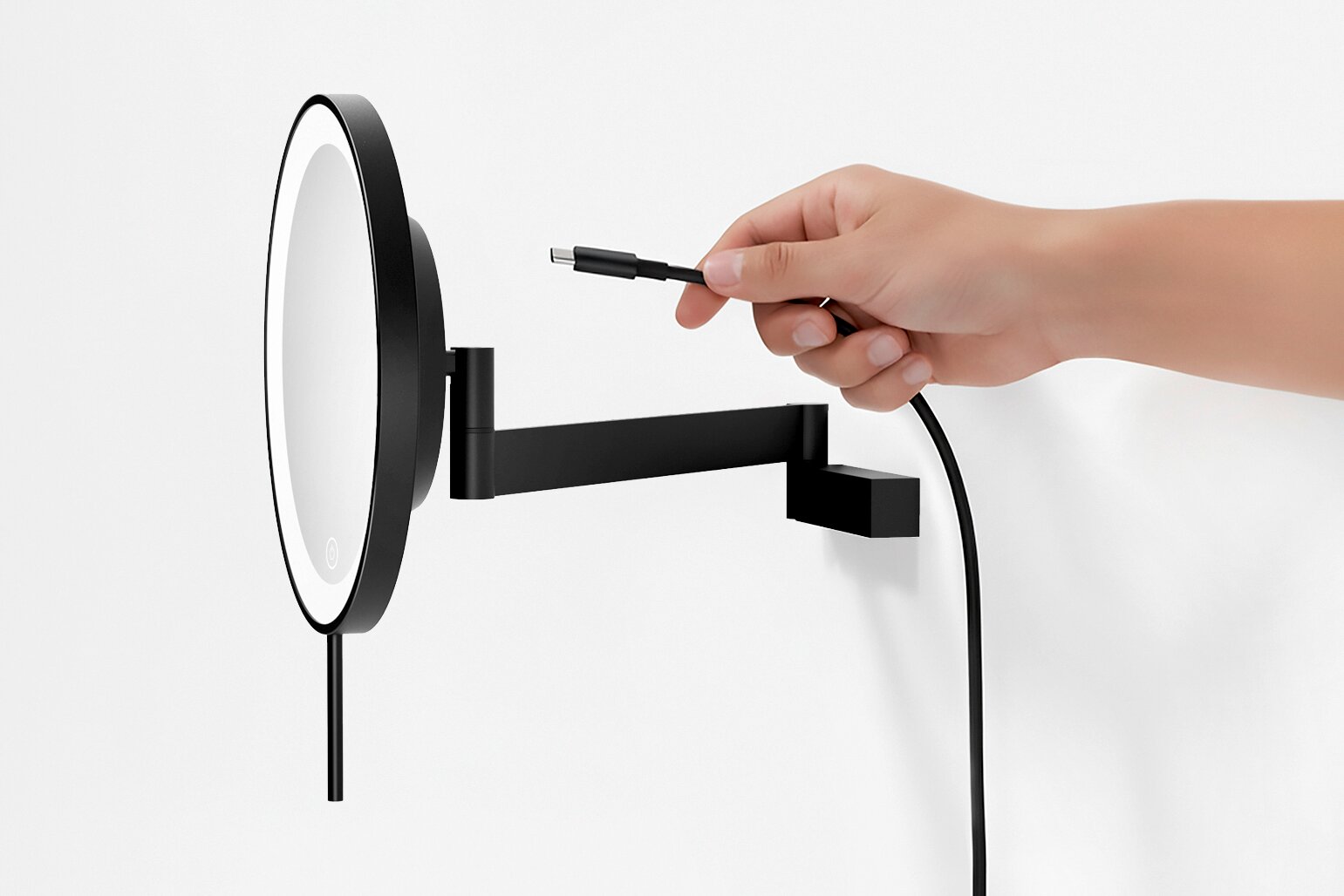 Zwarte ronde LED-wandspiegel met zwenkbare arm, USB-C-oplaadkabel is aangesloten, zijaanzicht tegen een witte achtergrond