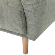 Nahaufnahme einer grünen Sofaecke mit Holzbein, Perspektive von der Seite.