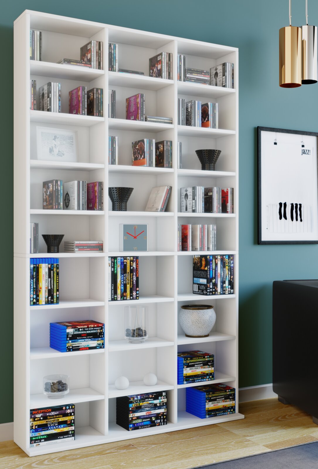 Großes weißes Bücherregal mit vielen offenen Fächern, gefüllt mit Büchern und DVDs sowie Deko-Objekten, im Wohnzimmer vor türkisfarbener Wand; frontale Perspektive mit leichter Ansicht von links.