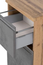 Nahaufnahme eines Unterschranks mit einer offenen Schublade, die eine graue Front und eine Holzoberfläche zeigt.