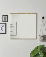 Moderner Wandspiegel mit Holzrahmen, frontal fotografiert, umgeben von Dekorationen wie Bildern und einer Pflanze.