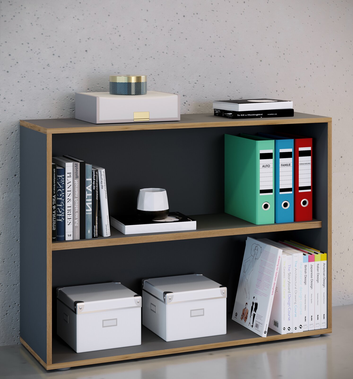 Modernes, niedriges Bücherregal in Holzoptik mit dunkelgrauen Fächern, dekoriert mit Büchern, Ordnern und weißen Aufbewahrungsboxen; Frontansicht aus leicht schräger Perspektive von links