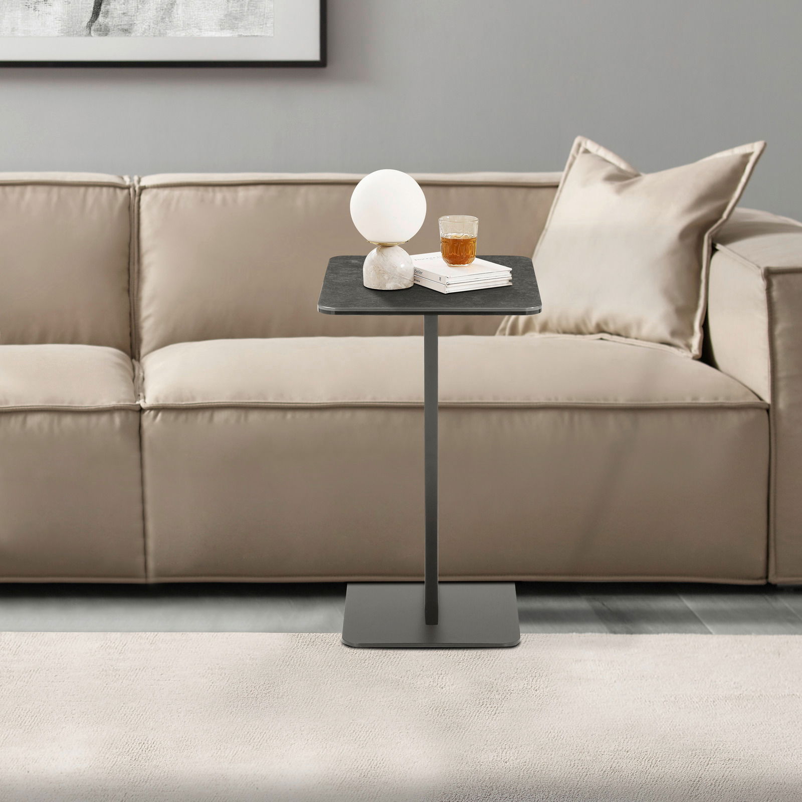 XORA Beistelltisch ROMEO Moderner Beistelltisch in schwarzem Design, frontal vor einem beigen Sofa platziert, mit einer Lampe und einem Glas auf der Tischplatte.