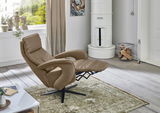 Beiger Relax-Sessel in einem modernen Wohnzimmer, seitliche Perspektive, mit ausgeklapptem Fußteil, auf einem Teppich vor einem Fenster.