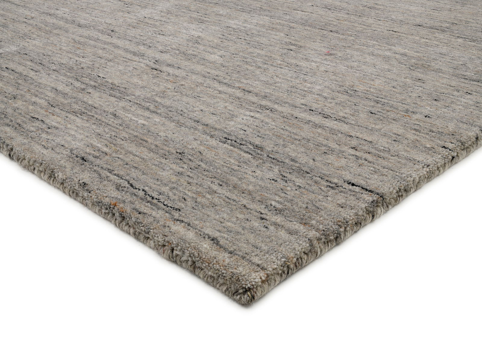 Grauer Wollteppich in Nahaufnahme, perspektivisch von der Seite fotografiert.
