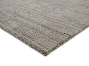 Grauer Wollteppich in Nahaufnahme, perspektivisch von der Seite fotografiert.