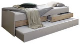 Seitliche Ansicht eines Duo-Liegebetts mit ausziehbarem Bettkasten und Schubladen, dekoriert mit Kissen und Decken.