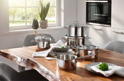Topfset Alicante 5-tlg aus Edelstahl auf einem Holztisch in einer modernen Küche, seitliche Perspektive