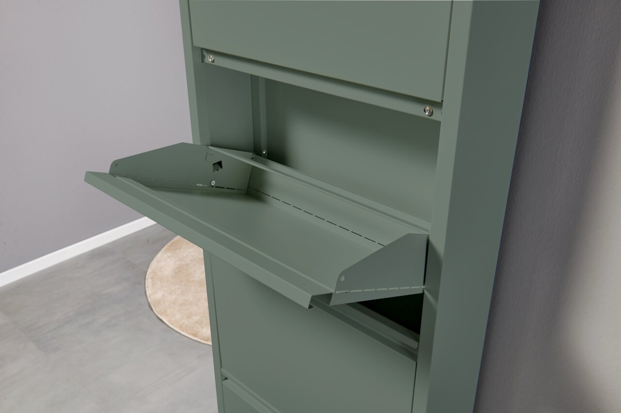 Schlanker, olivgrüner Metallschrank mit nach vorn aufgeklappter Klappe/Schreibfläche, gezeigt in schräger Seitenansicht von vorn rechts.