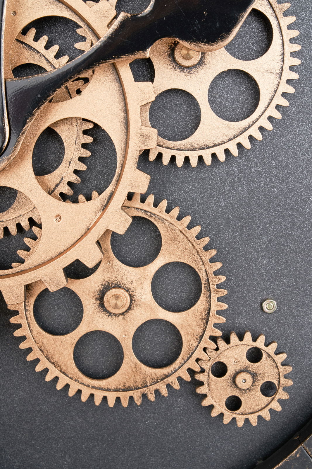 Nahaufnahme einer Wanduhr mit sichtbaren Zahnrädern in einem industriellen Design.