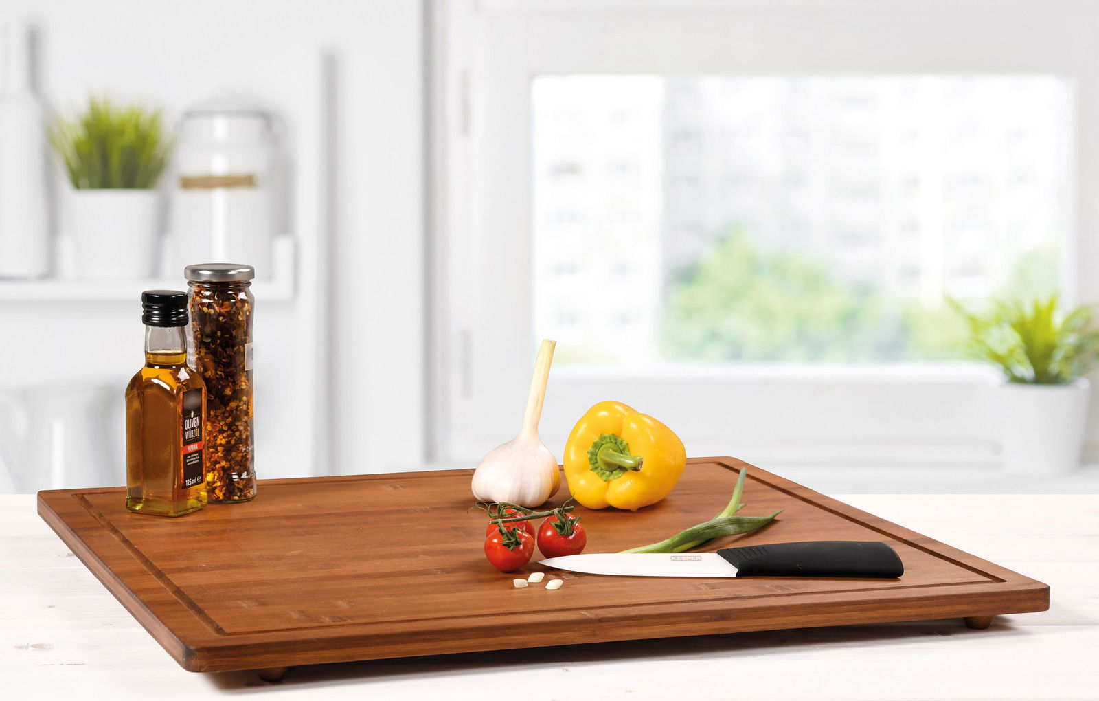 Kesper Schneide- und Abdeckplatte Holz-Schneidebrett mit frischem Gemüse und einem Messer, aus der Perspektive von schräg oben fotografiert.