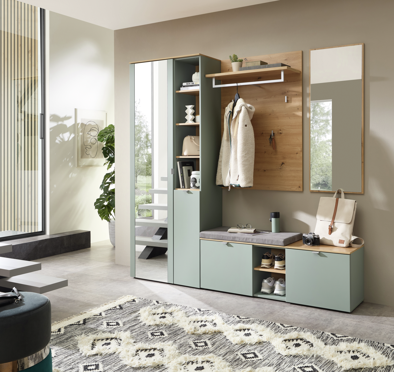 Modernes Garderoben-Set in einem hellen Raum mit Spiegel, Kleiderhaken, Sitzbank und Stauraum, seitliche Perspektive.