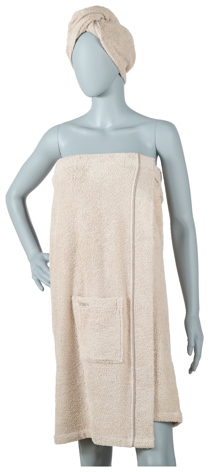 Wellnessset van beige badstof, bestaande uit een wikkelhanddoek met zakje en een bijpassende turban, vooraan op een etalagepop gepresenteerd.