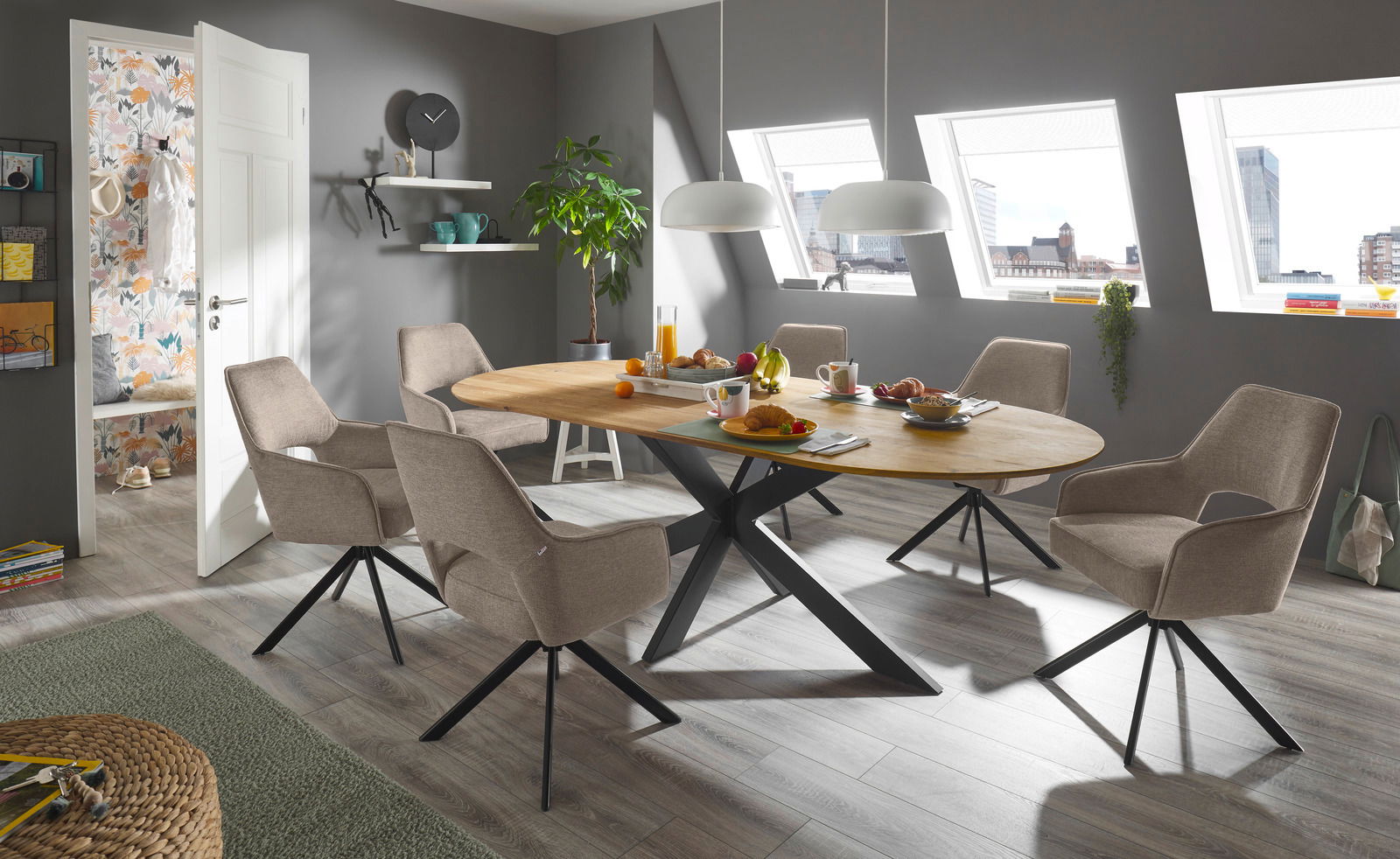 Esszimmer mit modernem Armlehnstuhl in Beige, um einen ovalen Holztisch mit schwarzem Metallgestell, seitliche Perspektive