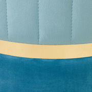 Nahaufnahme eines XORA Hockers DUO mit blauer Polsterung und goldener Zierleiste, seitliche Perspektive