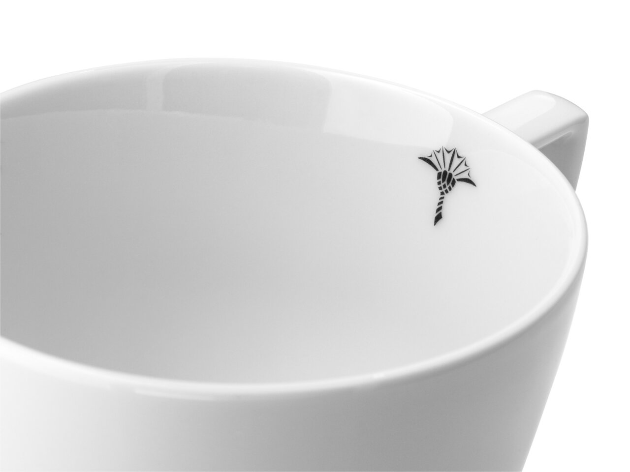 Nahaufnahme einer weißen Tasse mit schwarzem, stilisiertem Blumenmuster am Rand.