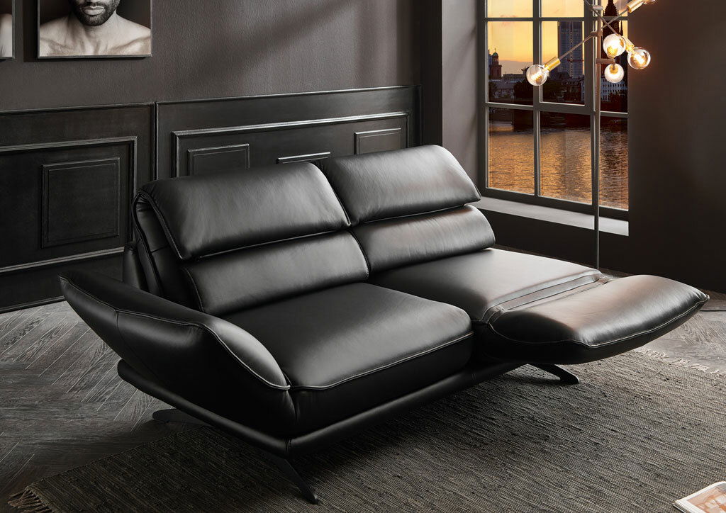 Schwarzes 2,5-Sitzer-Sofa in modernem Design, seitliche Perspektive, mit verstellbaren Kopfstützen und eleganten Metallfüßen, in einem stilvollen Raum mit Blick auf ein Fenster bei Sonnenuntergang.