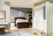 Moderne, witte hangkast met twee deuren, gefotografeerd vanaf de voorkant, in een stijlvol ingerichte slaapkamer.