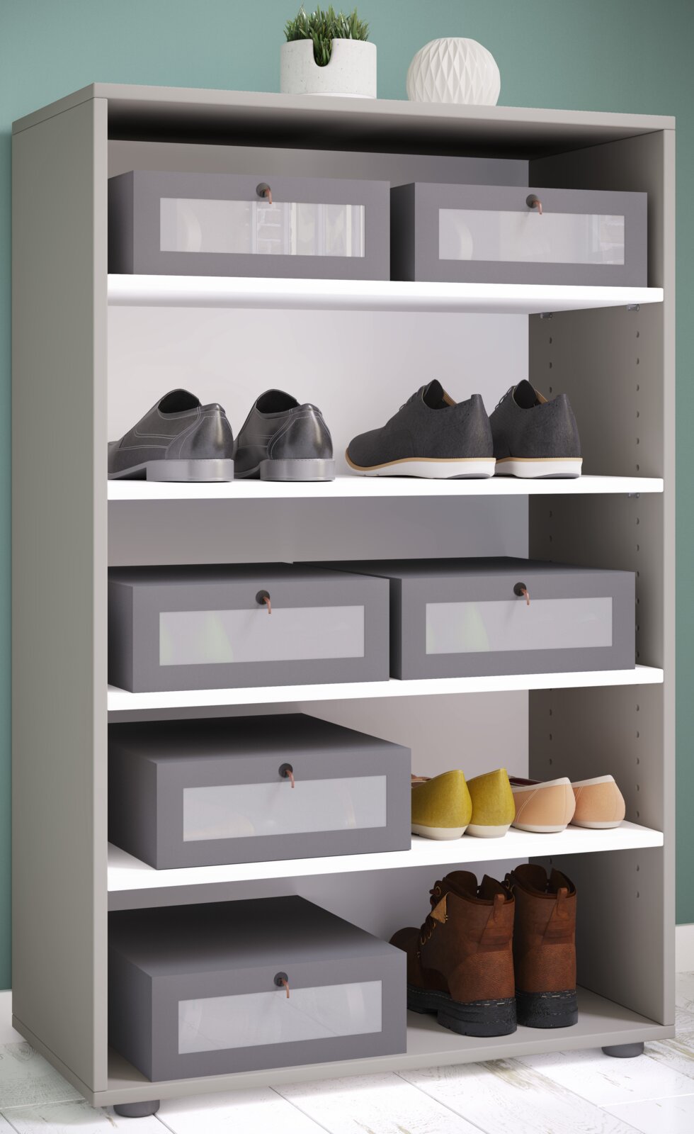 Modernes graues Schuhregal mit mehreren weißen Einlegeböden, Schuhen und grauen Aufbewahrungsboxen, darauf Deko-Pflanze und Kugelvase; Ansicht von vorne in leichter Schrägperspektive.