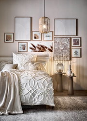 Een gezellige slaapkamer met een stijlvolle inrichting, een zachte bontdeken en elegant beddengoed in neutrale tinten, gezien van voren.