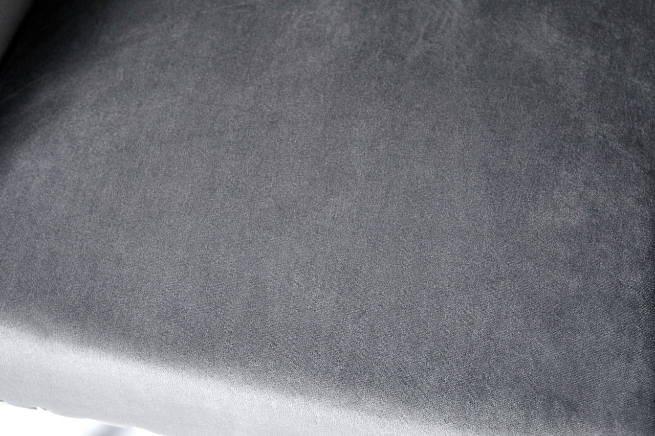 Nahaufnahme eines grauen Stuhlpolsters aus Stoff, von oben betrachtet.