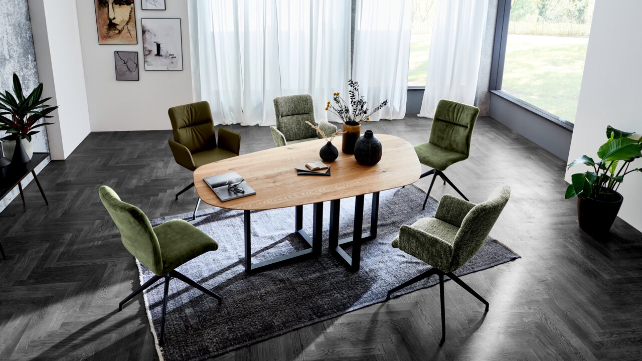 Moderner Esstisch DANA von Dieter Knoll in einem eleganten Esszimmer, umgeben von grünen Stühlen, aus der Vogelperspektive.