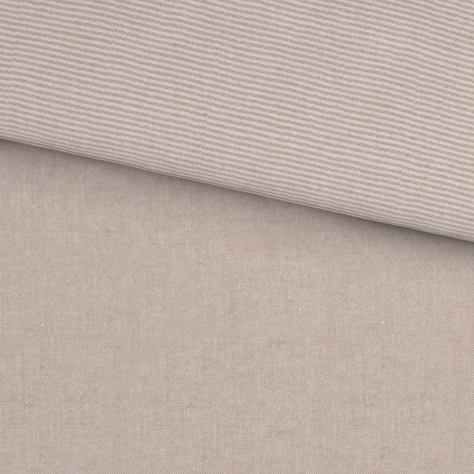 Nahaufnahme einer Wendebettwäsche mit einer Seite in feinem Streifenmuster und der anderen in einfarbigem Beige.