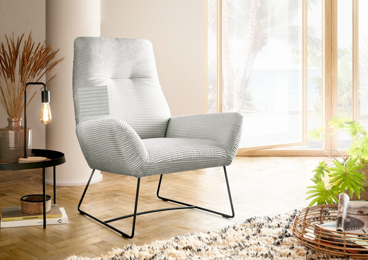 Lounge Handmade Sessel LH-BEN Moderner Sessel in hellgrauem Stoff mit Metallbeinen, seitliche Perspektive, in einem hellen Raum mit großen Fenstern und Pflanzen.