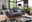 Graues Megasofa 2-Sitzer in modernem Wohnzimmer mit großen Fenstern, seitliche Perspektive