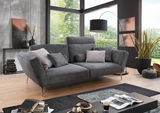 Graues Megasofa 2-Sitzer in modernem Wohnzimmer mit großen Fenstern, seitliche Perspektive