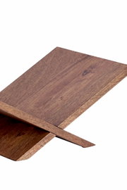 Schräg von oben gezeigte Detailansicht einer kreuzförmigen Möbelkonstruktion aus warmbraunem Holz mit natürlicher Maserung.