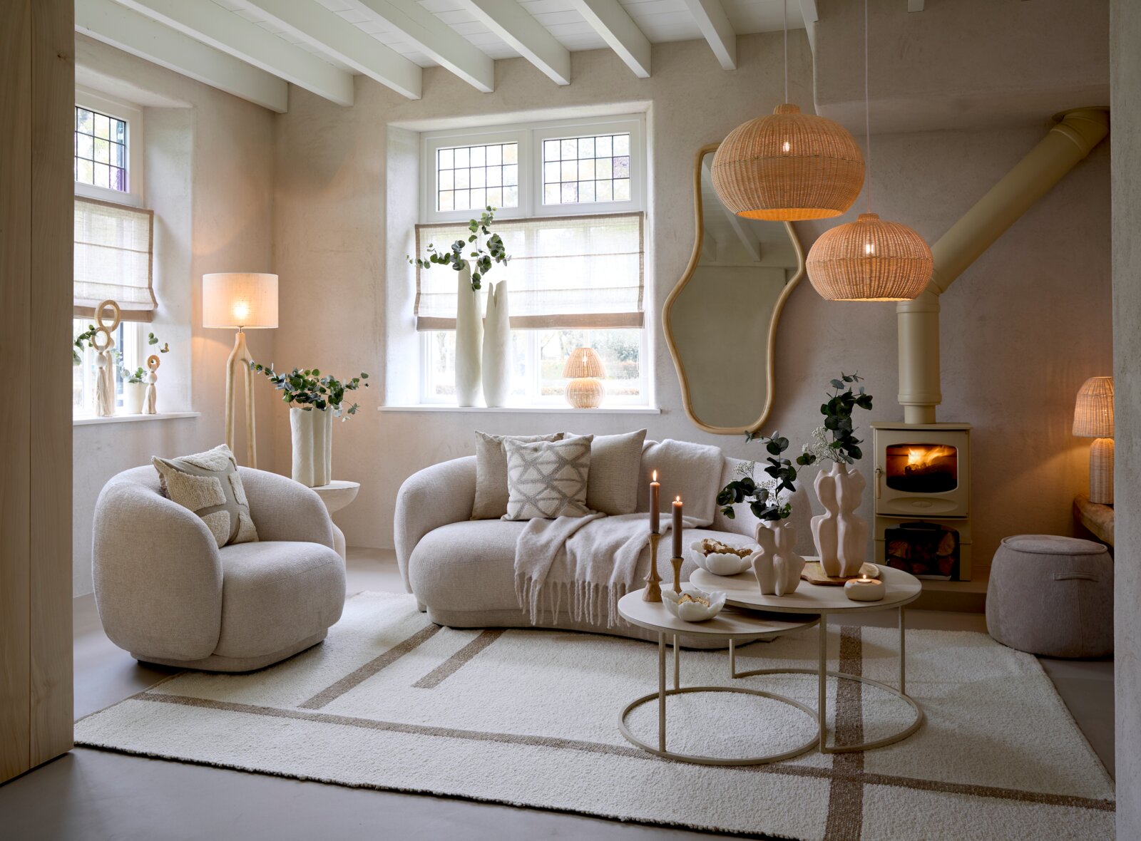 Gezellige woonkamer met een moderne, beige fauteuil in een uitnodigende hoek, omringd door stijlvolle decoraties en natuurlijk licht.