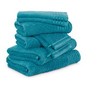 Ein Stapel von türkisfarbenen Handtüchern aus einem 8-teiligen Set, fotografiert aus einer leicht seitlichen Perspektive.