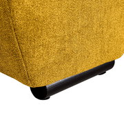 Nahaufnahme der unteren Ecke eines gelben Big-Sofas mit schwarzem Fuß, seitliche Perspektive.