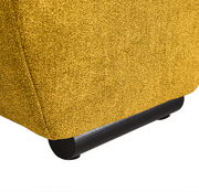 Nahaufnahme der unteren Ecke eines gelben Big-Sofas mit schwarzem Fuß, seitliche Perspektive.