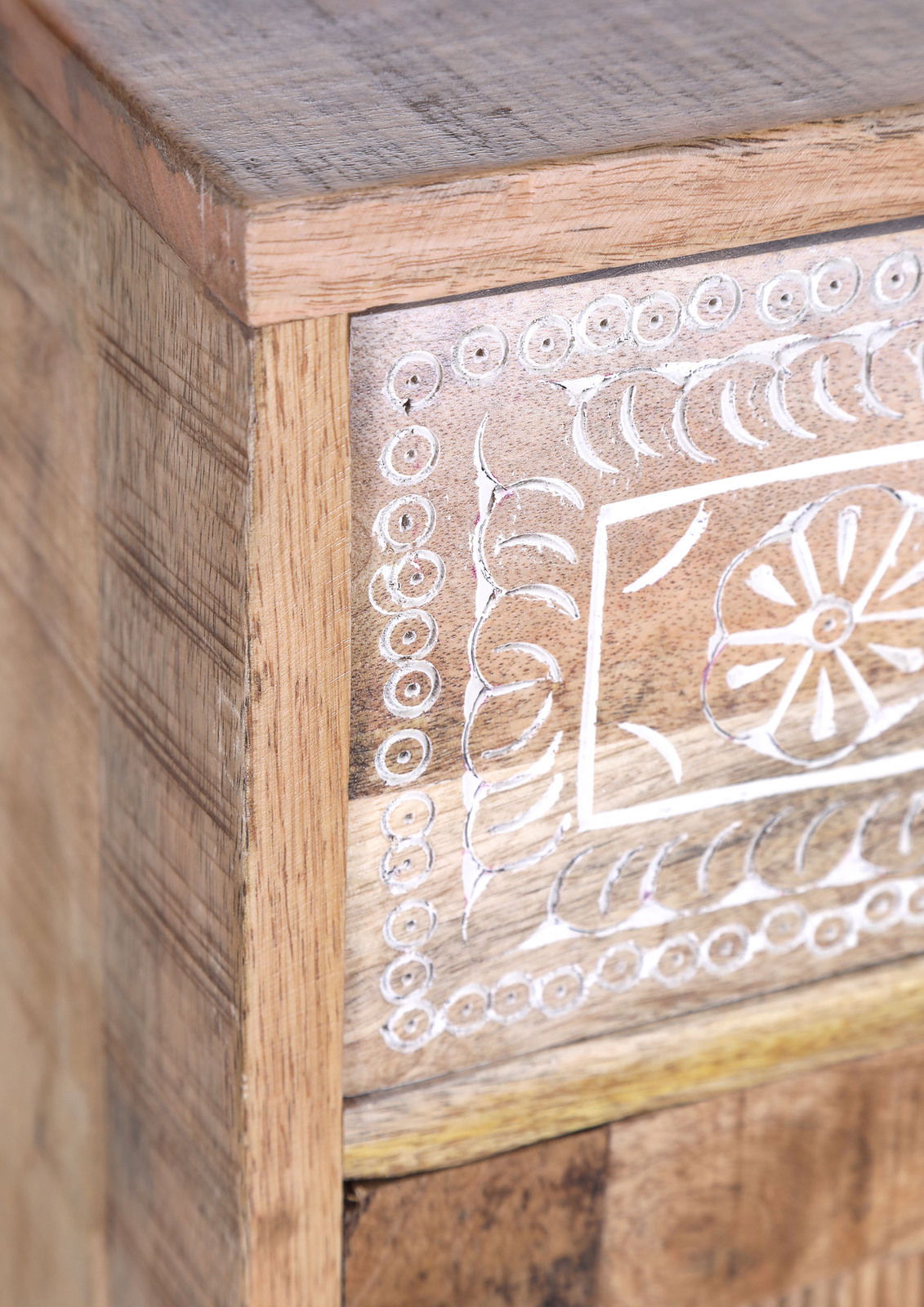 Detailansicht eines Holzmöbels mit geschnitztem Blumenmuster auf der Vorderseite.