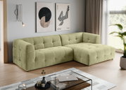 Modernes, hellgrünes, gepolstertes L-förmiges Ecksofa mit gesteppter Kassettenoptik und rechter Ottomane in einem Wohnzimmer; Perspektive: frontale 3/4-Ansicht von links.