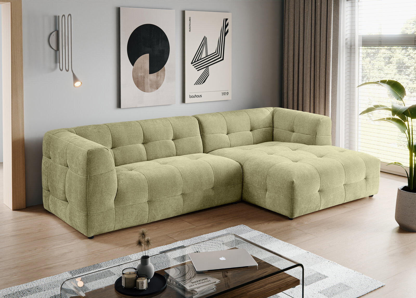 Modernes, hellgrünes, gepolstertes L-förmiges Ecksofa mit gesteppter Kassettenoptik und rechter Ottomane in einem Wohnzimmer; Perspektive: frontale 3/4-Ansicht von links.