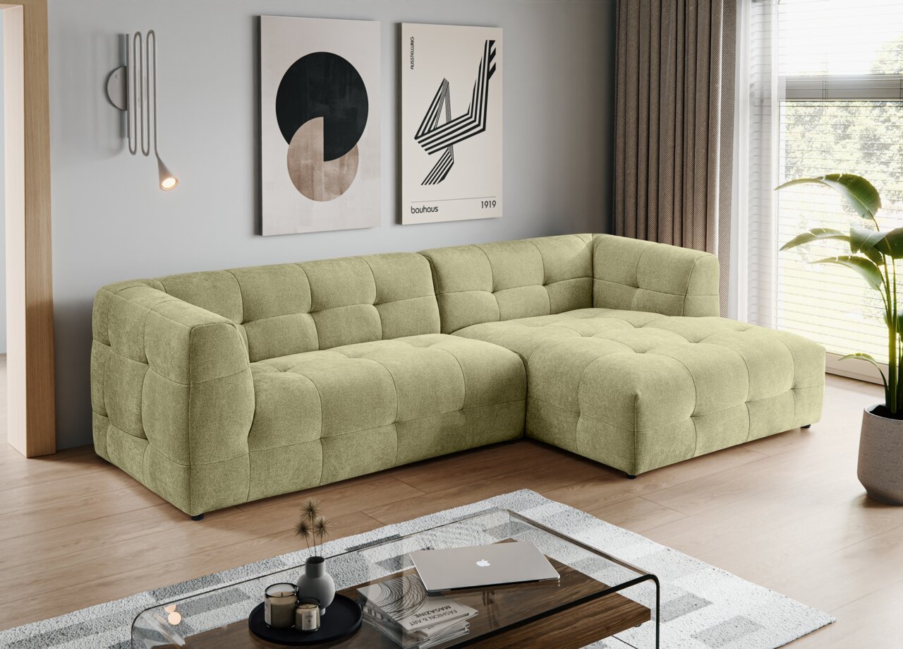 MID.YOU Ecksofa TENSO Modernes, hellgrünes, gepolstertes L-förmiges Ecksofa mit gesteppter Kassettenoptik und rechter Ottomane in einem Wohnzimmer; Perspektive: frontale 3/4-Ansicht von links.