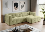 Modernes, hellgrünes, gepolstertes L-förmiges Ecksofa mit gesteppter Kassettenoptik und rechter Ottomane in einem Wohnzimmer; Perspektive: frontale 3/4-Ansicht von links.