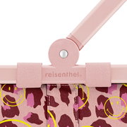 Detailaufnahme aus Frontperspektive: rosafarbener reisenthel-Tragegriff mit Niete und Klettlaschen an einer Tasche mit pink-bordeauxfarbenem Leo-Muster und gelben Smiley-Prints