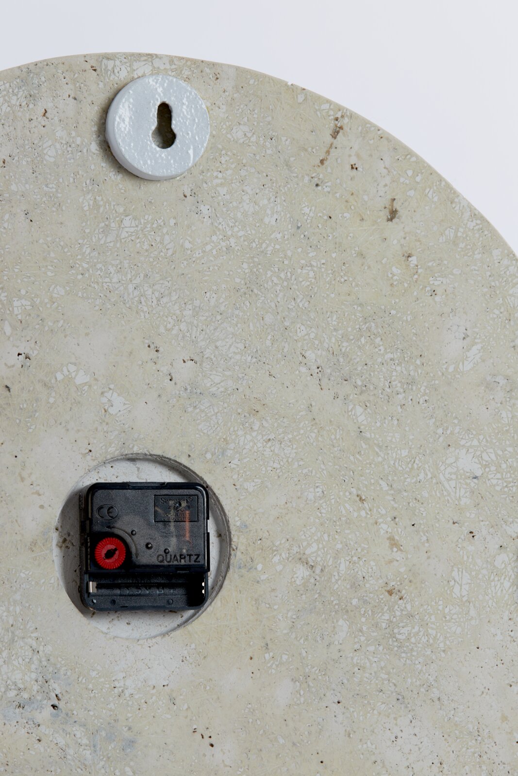 Achterkant van een horloge met quartz uurwerk en ophanging.