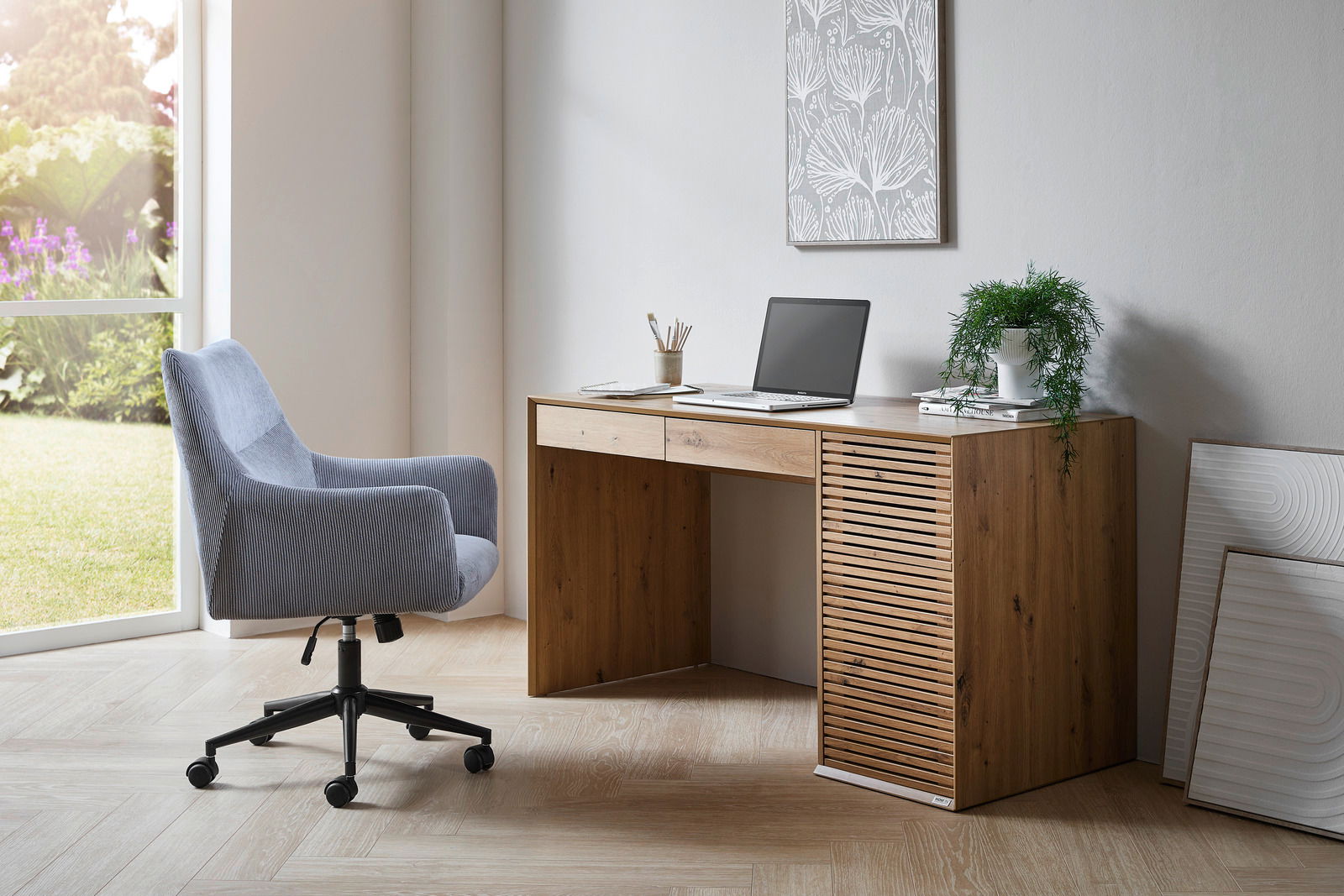 Grauer Drehstuhl mit Armlehnen in einem modernen Büro, seitliche Perspektive