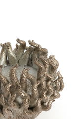 Nahaufnahme eines kunstvoll gestalteten Teelichthalters mit tentakelartigen Strukturen in metallischer Optik.