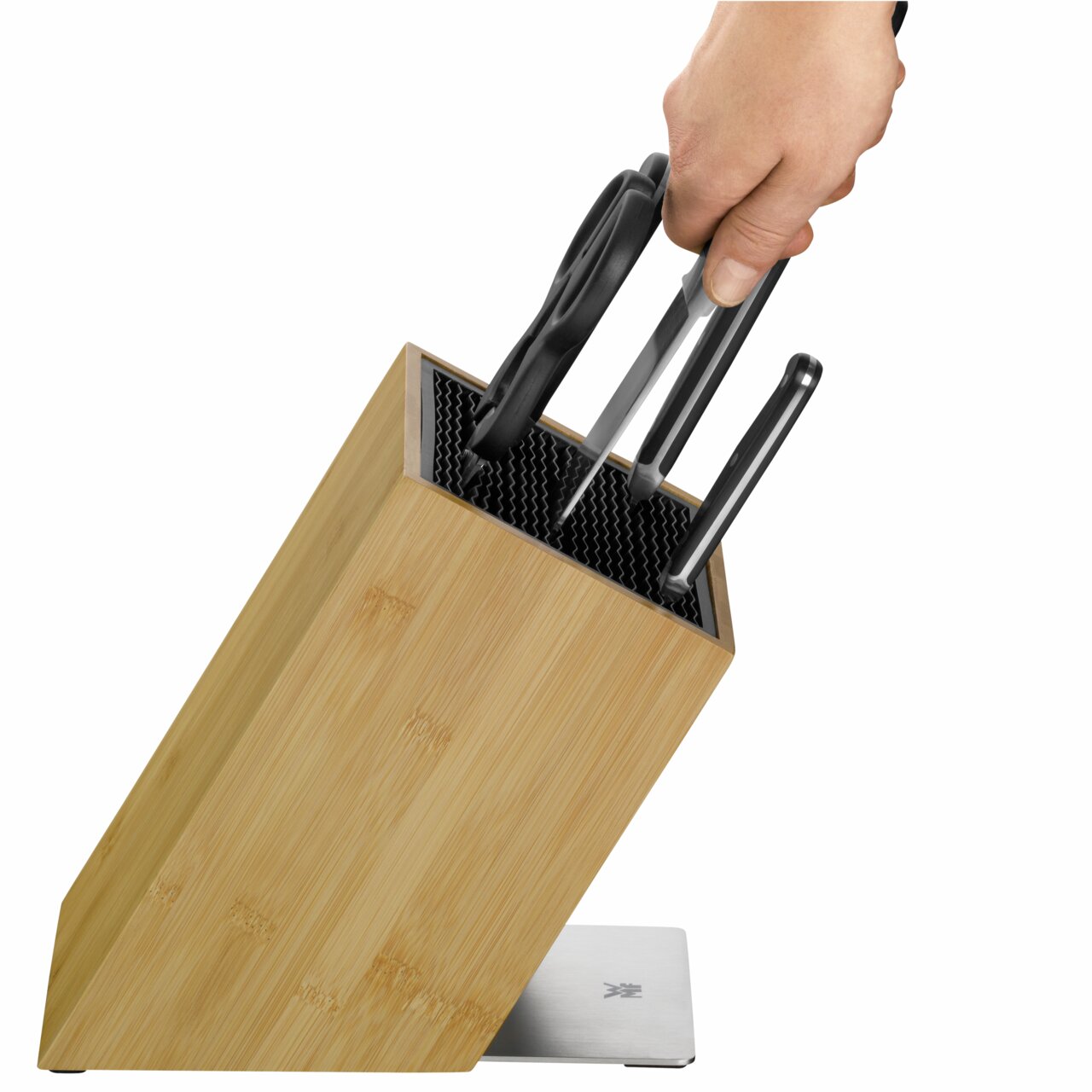 Messerblock aus Holz mit mehreren Messern und einer Schere, von oben betrachtet, eine Hand greift nach einem Messer.