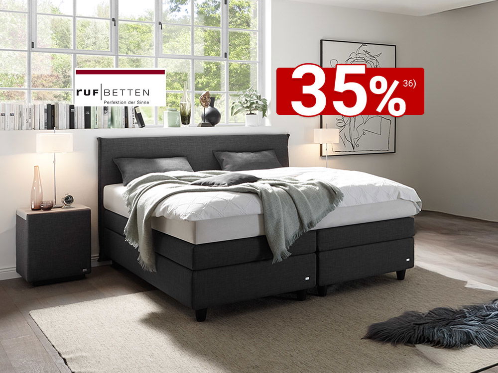 Modernes Boxspringbett in Grau in hellem Schlafzimmer mit großem Fenster